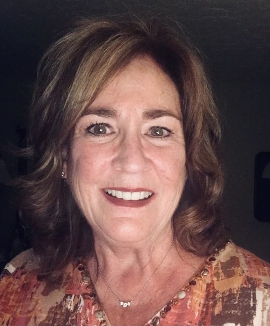 Woman smiling at camera, professional headshot for dental practice website